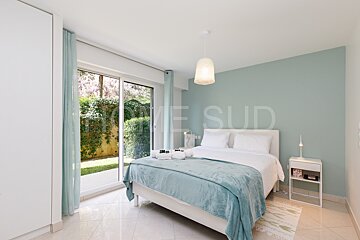 A bedroom with a bed and a sliding glass door that says home sud