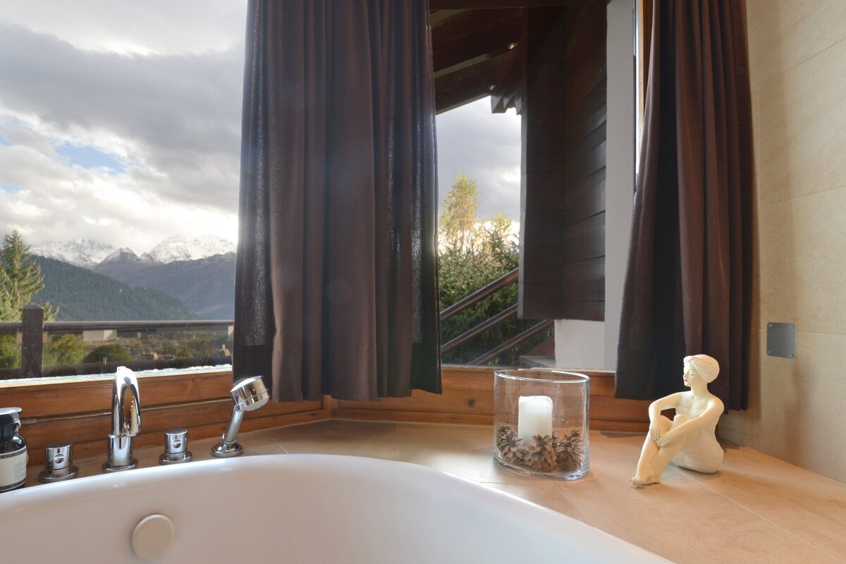 A bathtub in a bathroom with a view of the mountains
