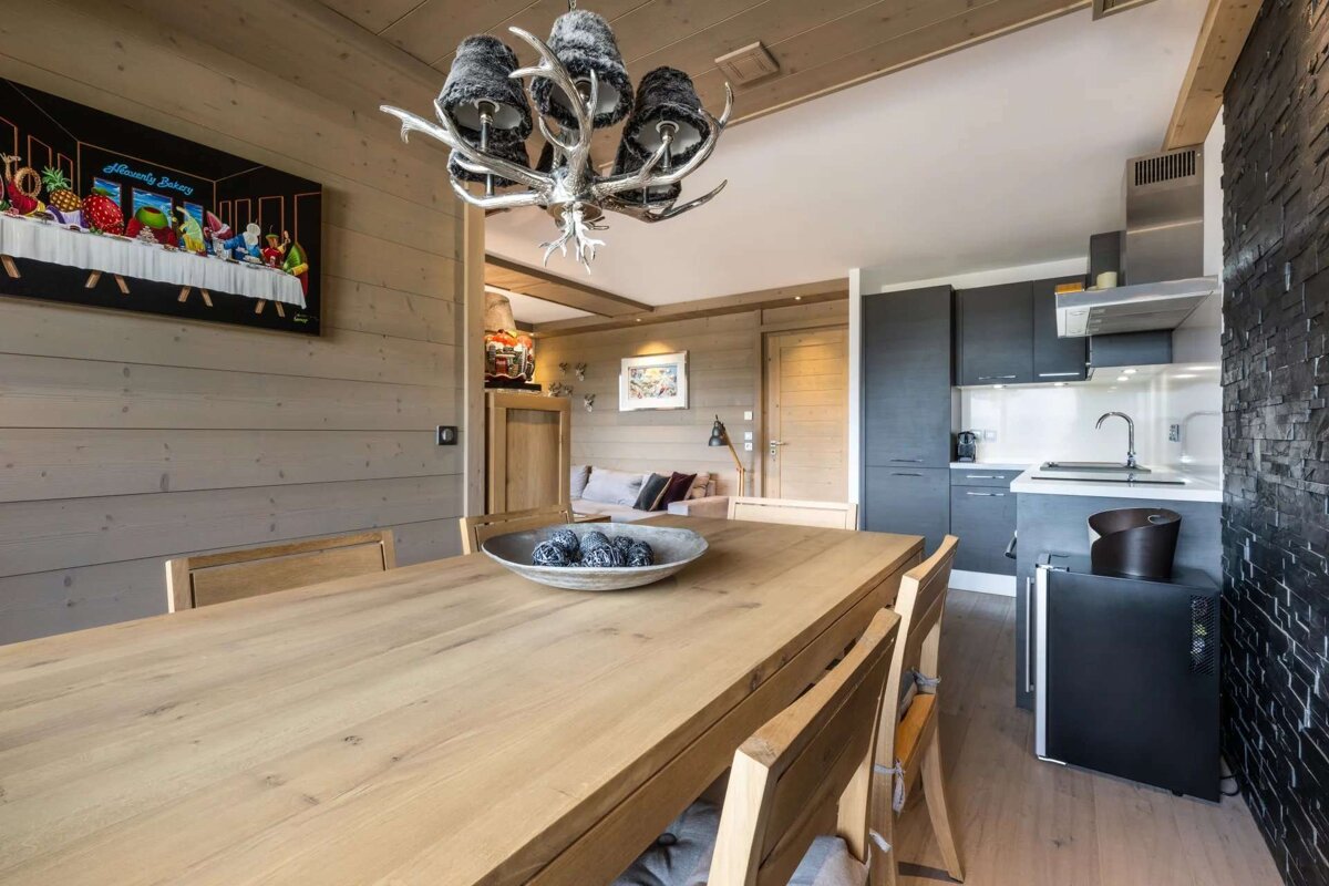 A dining room table with a bowl of fruit on it