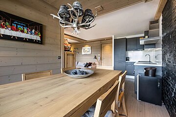 A dining room table with a bowl of fruit on it