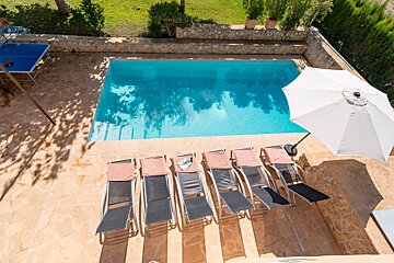 A swimming pool with a ping pong table in the background