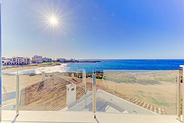 A view of the ocean from a balcony with a glass railing