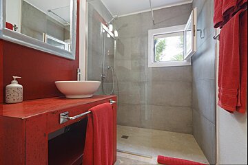 A bathroom with a sink and a walk in shower