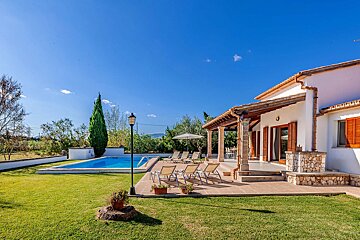 A white house with a large swimming pool in the backyard