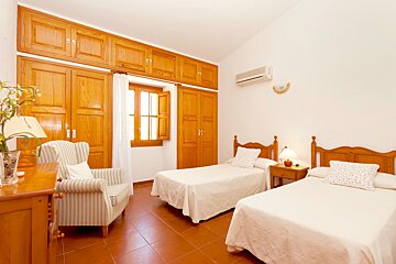 A bedroom with two twin beds and a chair