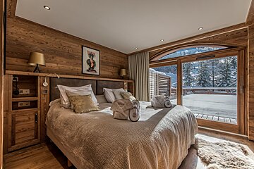 A bedroom with a large bed and a large window