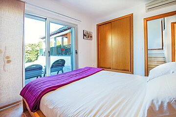 A bedroom with a purple blanket on the bed
