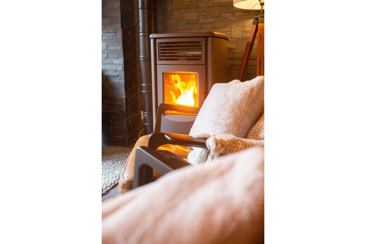 A wood stove is lit up in a living room
