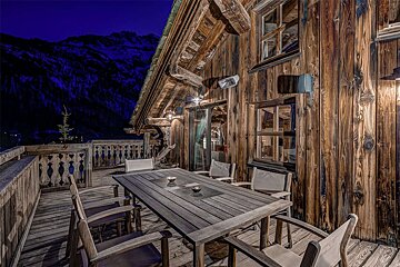 A wooden deck with a table and chairs at night