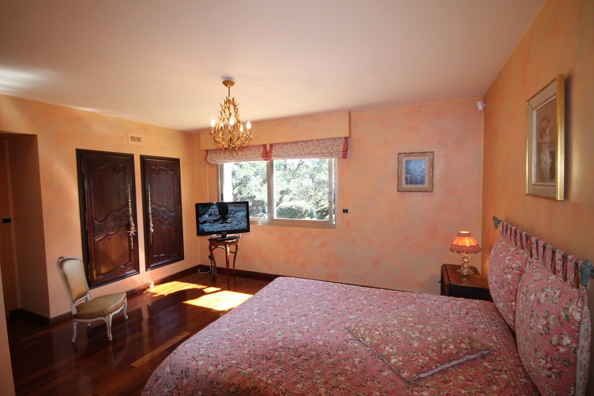 A bedroom with a large bed and a flat screen tv