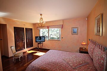 A bedroom with a large bed and a flat screen tv