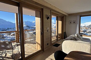 A living room with a view of snowy mountains