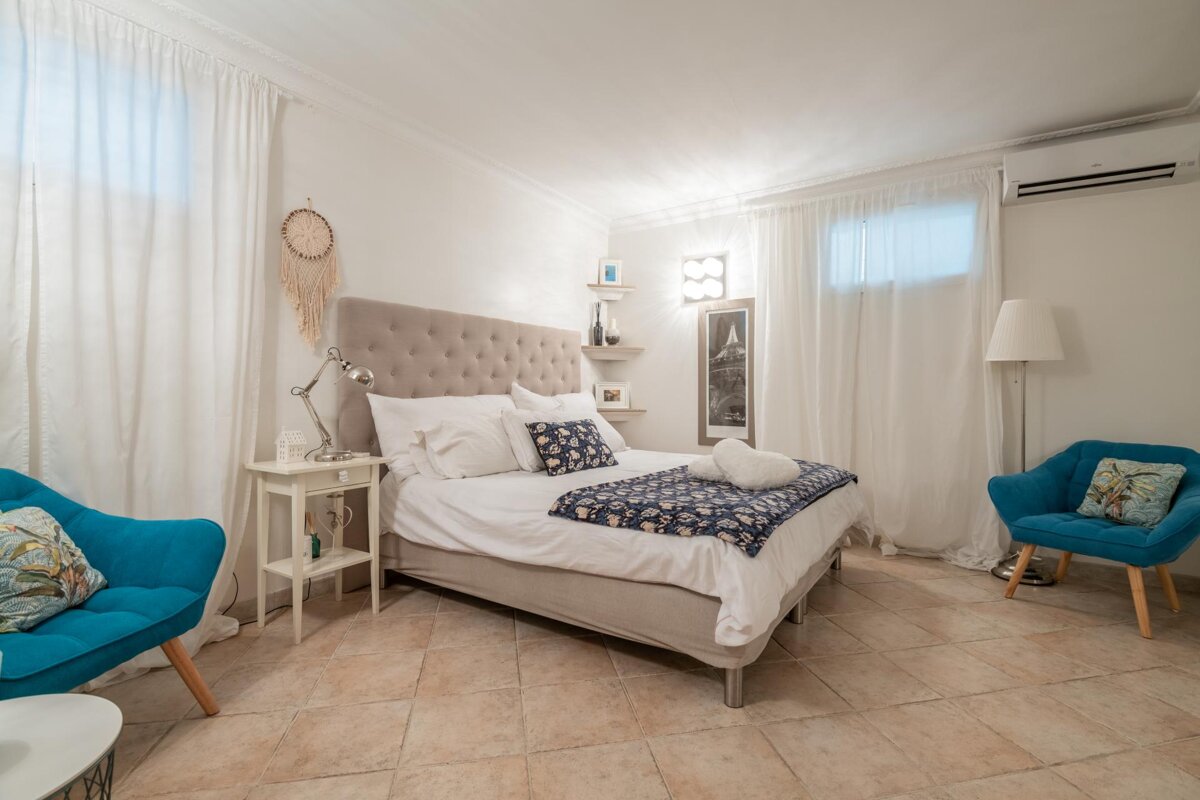 A bedroom with a large bed and two chairs