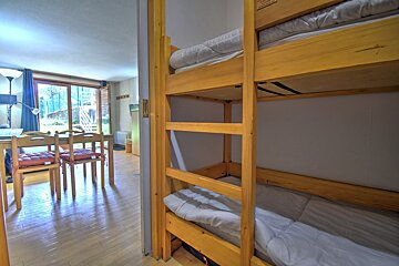 A room with bunk beds and a table and chairs