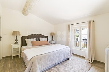 A bedroom with a bed and lamps and a sign that says janssens immobilier