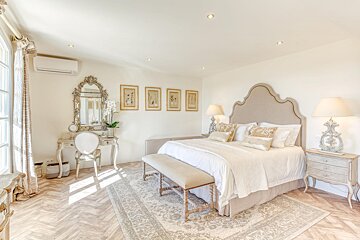 A bedroom with a large bed and a mirror