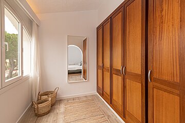 A walk in closet with wooden cabinets and a mirror