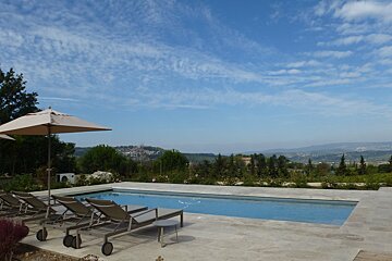 A large swimming pool surrounded by chairs and umbrellas