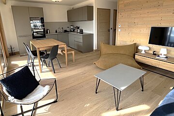 A living room with a table and chairs and a television