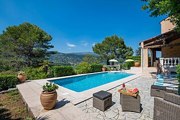 A large swimming pool in front of a house