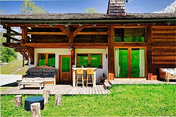 A wooden house with a couch and a table in front of it