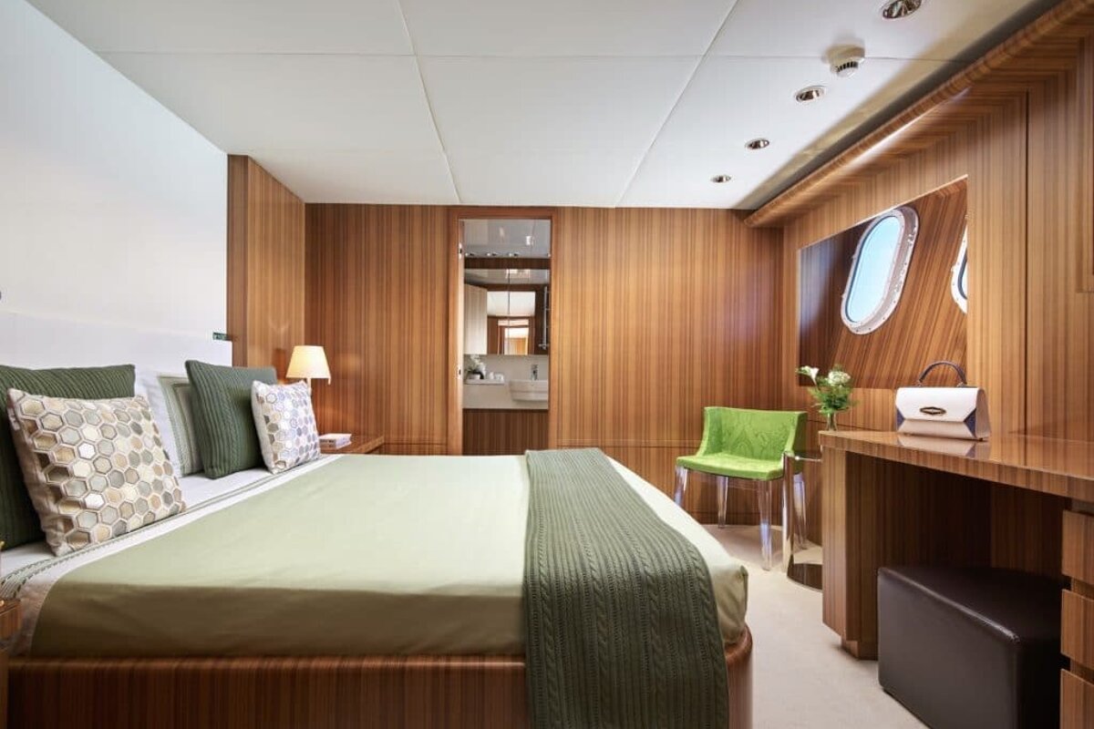 A bedroom with a large bed and a green chair