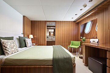 A bedroom with a large bed and a green chair