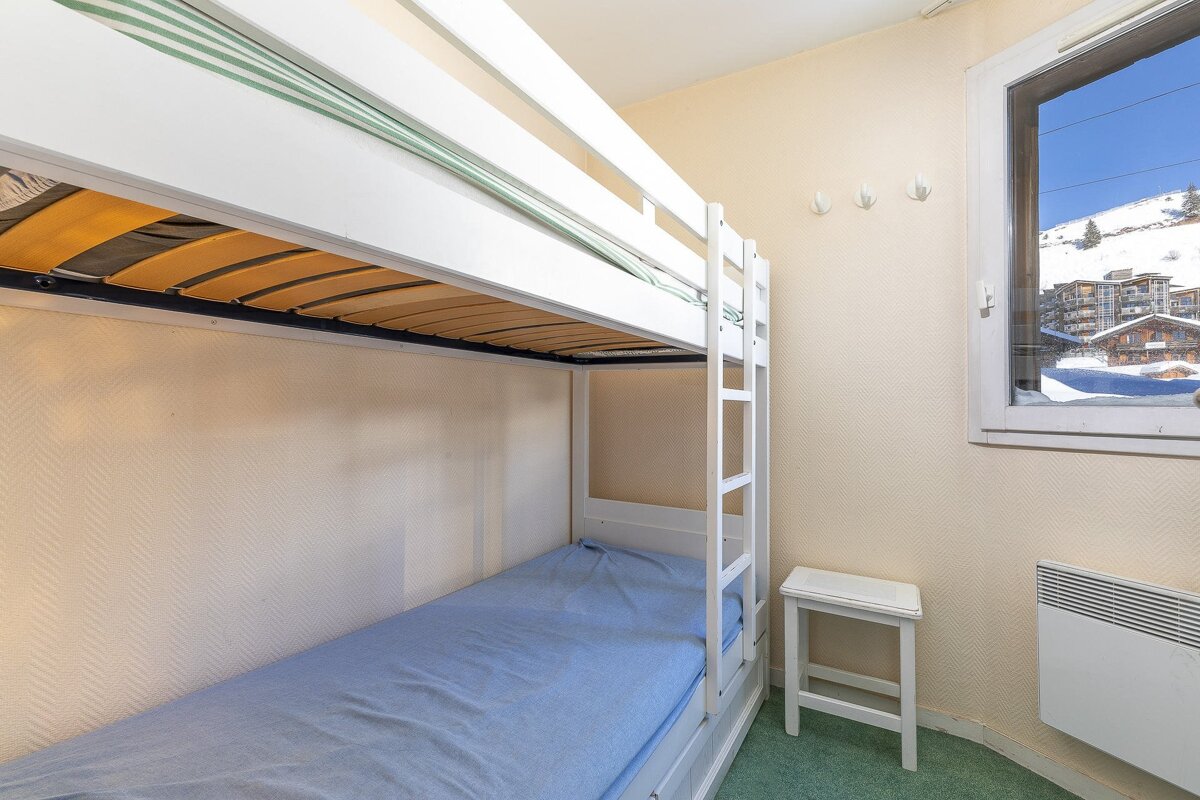 A bunk bed in a room with a window
