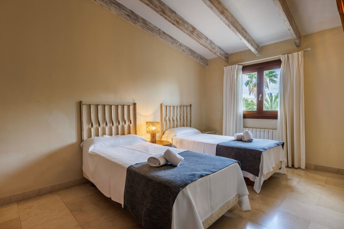 A bedroom with two twin beds and a window