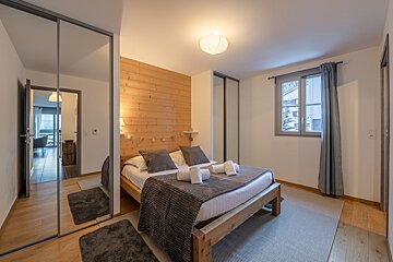 A bedroom with a large bed and a window