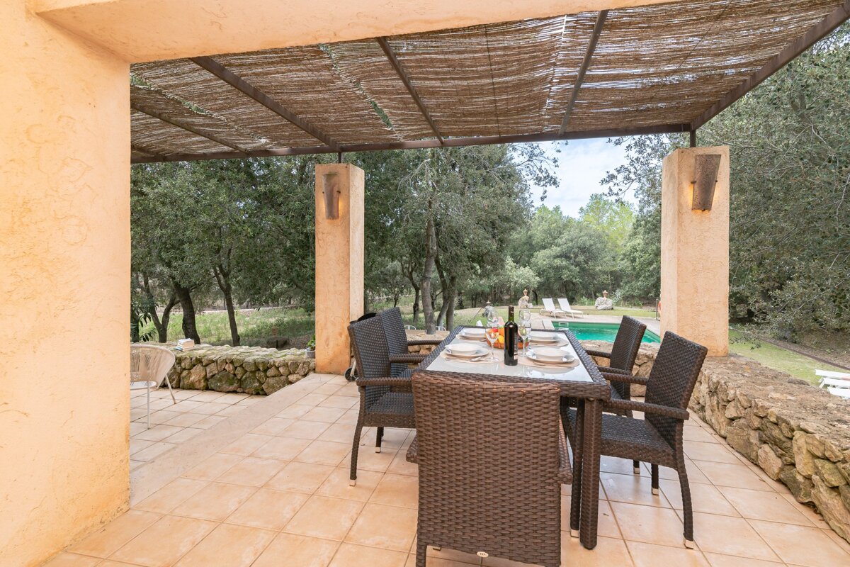 A patio with a table and chairs and a bottle of wine