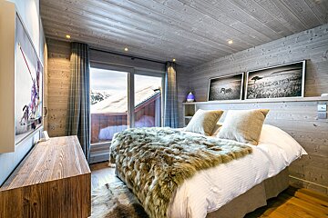 A bedroom with a fur blanket on the bed