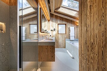 A bathroom with wooden walls and a skylight