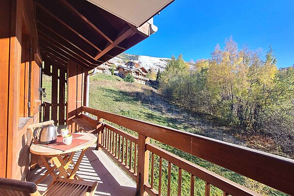 A balcony with a table and chairs and a view of the mountains