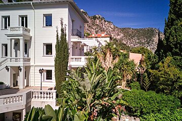 A large white building with a mountain in the background