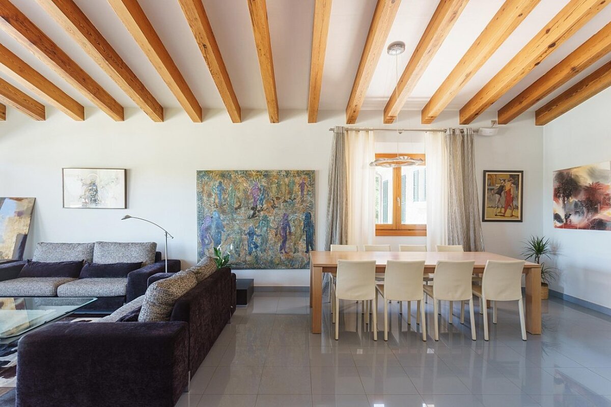 A living room with a table and chairs and a painting on the wall