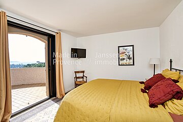 A bedroom with a yellow bed and a picture on the wall that says made in provence