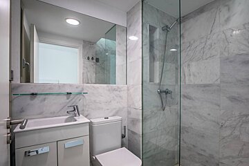 A bathroom with a toilet a sink and a shower