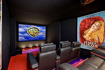 A movie theater with a screen that says ' warner bros ' on it