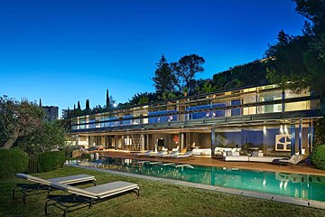 A large house with a swimming pool in front of it