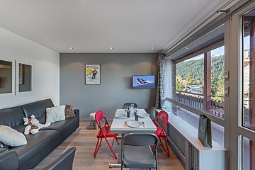 A living room with a couch and a dining table