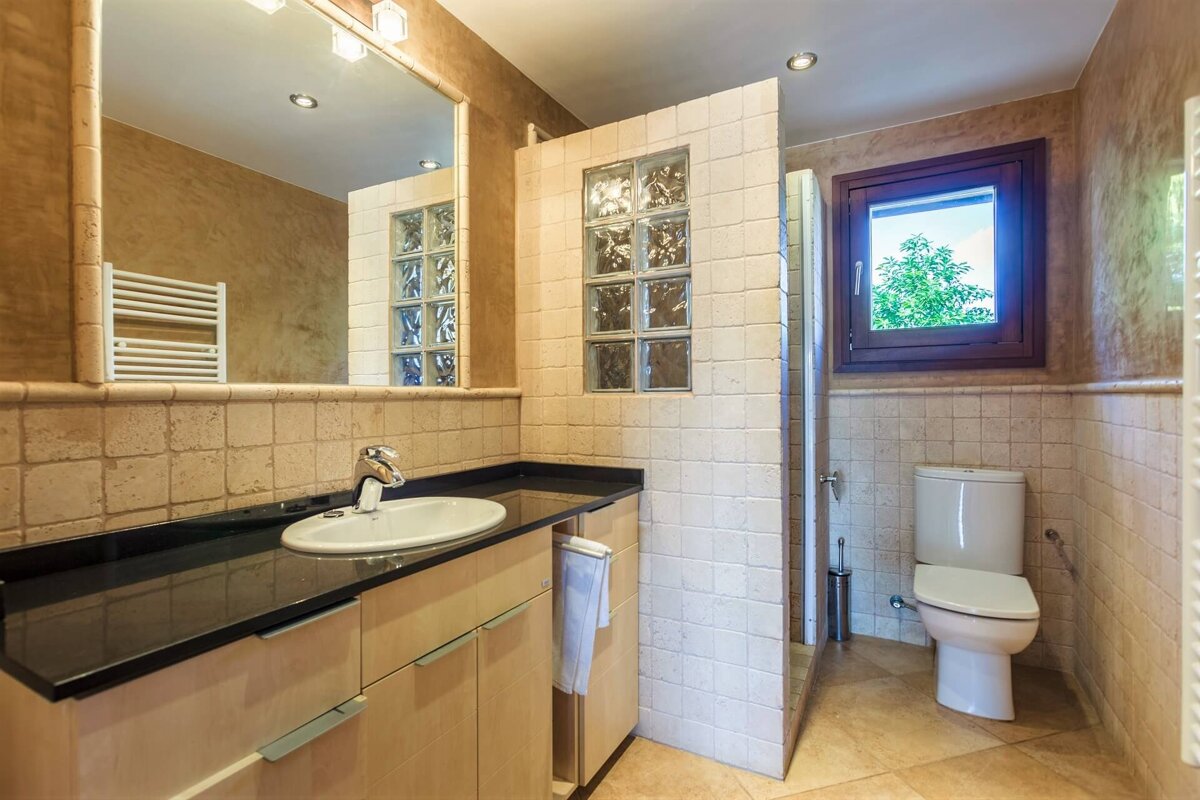 A bathroom with a toilet sink and mirror