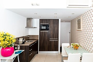 A kitchen with wooden cabinets and a microwave