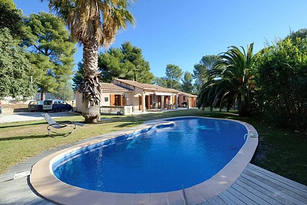 A house with a large swimming pool in front of it