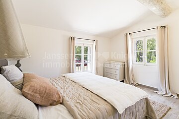 A bedroom with a bed and a dresser and the word janssen on the wall