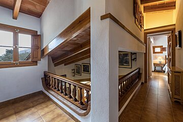 A hallway with a wooden railing and a window