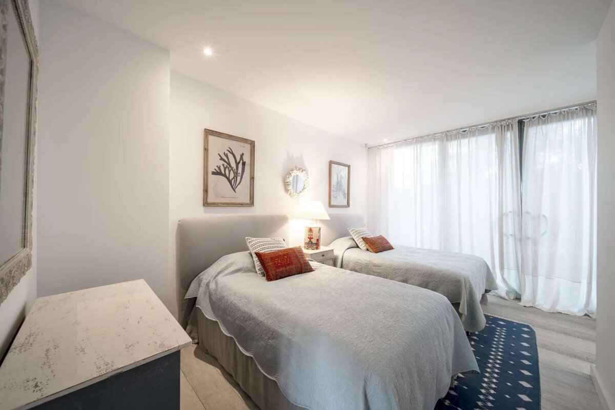 A bedroom with two twin beds and a dresser