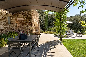 A patio with a table and chairs under a canopy that says made in provence