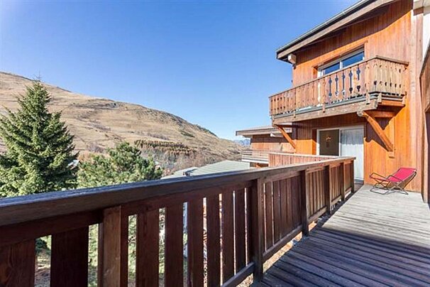 A balcony with a view of mountains and trees