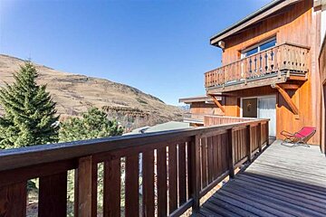 A balcony with a view of mountains and trees